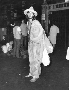 Barefooted hippy waiting for a train to the Isle of Wight, London, 1970.