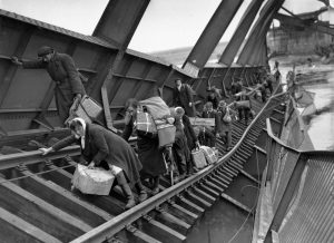 Displaced persons crossing blown-up bridge at Tangermunde in 1945.