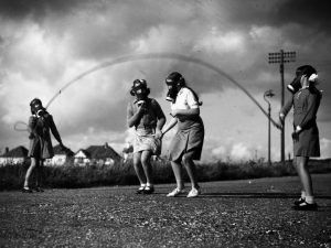 Kids adapt to World War 2nd hardship, play in gas masks, 1940.