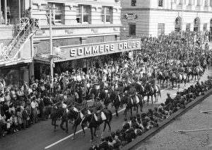 Crowd watches the first Armistice Day parade following the end of war, 1945.