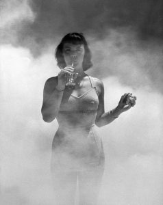 DDT sprayed on model to prove safety of food. DDT was later found to be a carcinogen and banned in 1972.